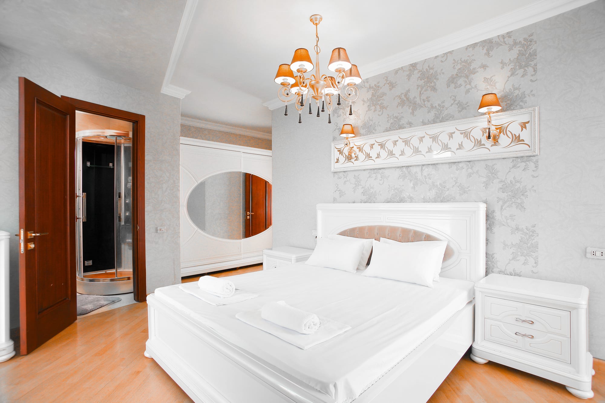 Bright white bedroom with crisp bedding and folded towels